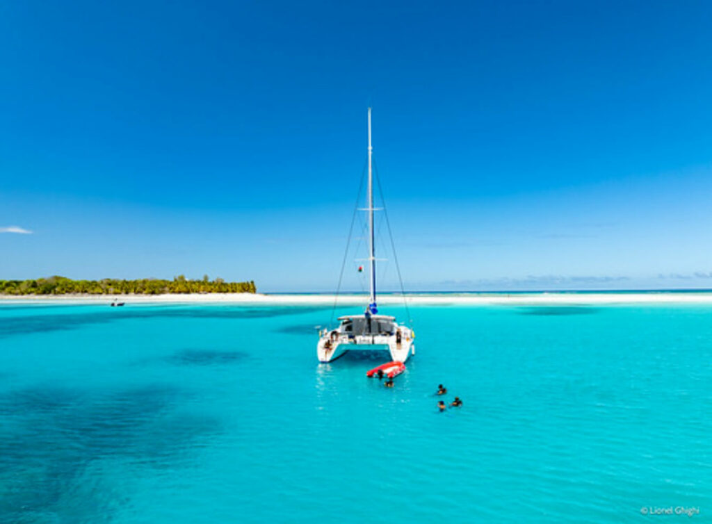 Bateau de croisière longeant les côtes paradisiaques de Madagascar avec lagon turquoise et ciel bleu